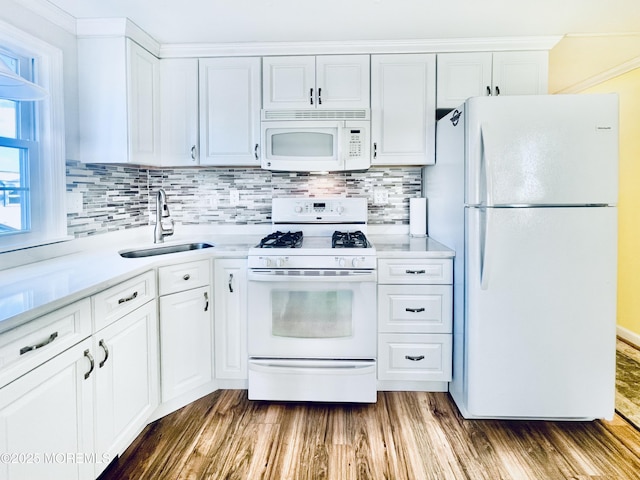 kitchen with white cabinetry, wood-type flooring, sink, backsplash, and white appliances