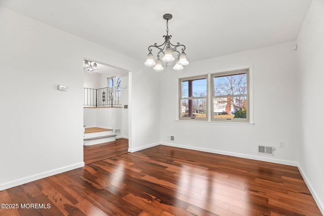 unfurnished room featuring hardwood / wood-style flooring and a chandelier