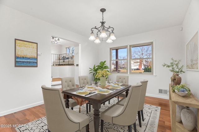 dining area featuring an inviting chandelier and light hardwood / wood-style floors