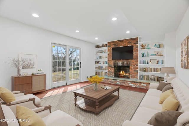 living room featuring a brick fireplace, hardwood / wood-style floors, and built in features