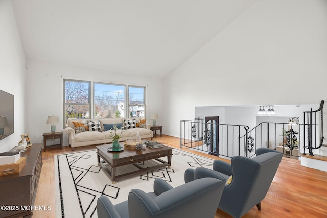 living room with high vaulted ceiling and light hardwood / wood-style flooring