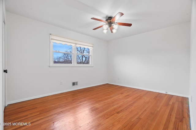 spare room featuring hardwood / wood-style floors and ceiling fan