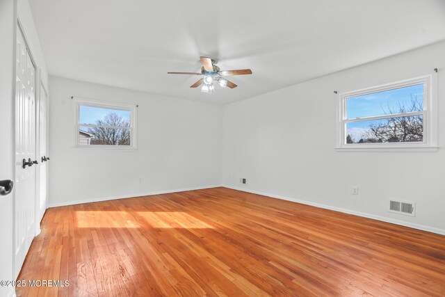 spare room with ceiling fan, plenty of natural light, and light hardwood / wood-style floors