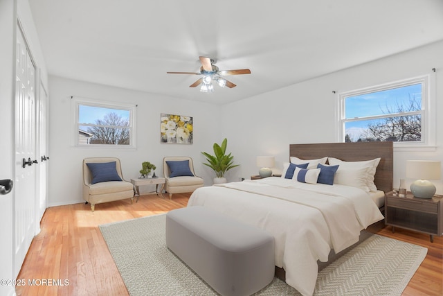 bedroom with multiple windows, light hardwood / wood-style floors, and ceiling fan