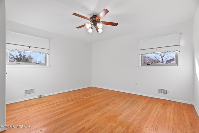 empty room with ceiling fan and light hardwood / wood-style floors