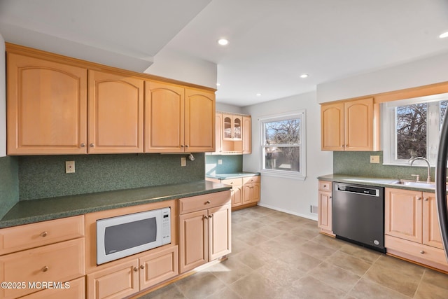 kitchen with sink, light brown cabinets, dishwashing machine, white microwave, and backsplash