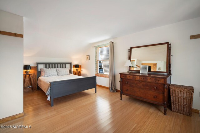 bedroom featuring light hardwood / wood-style flooring and vaulted ceiling