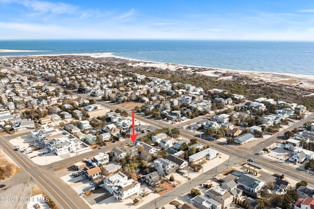 bird's eye view with a water view and a beach view