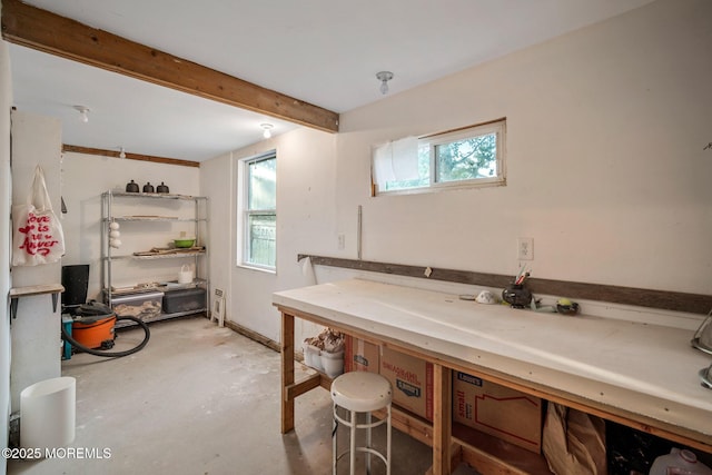 bathroom featuring beam ceiling, concrete flooring, and a workshop area