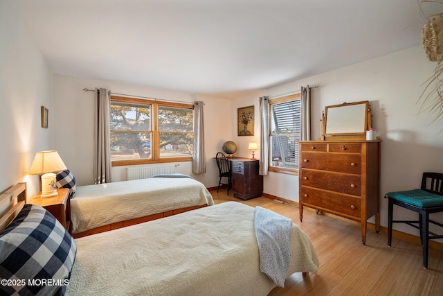 bedroom featuring radiator and light wood-type flooring