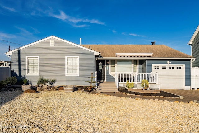 ranch-style home with a porch and a garage