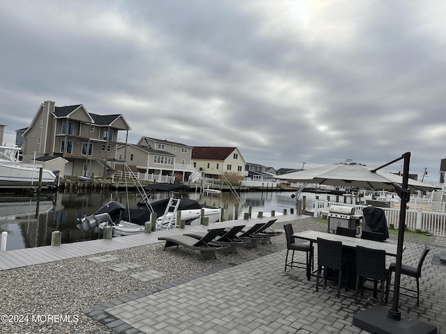 view of patio / terrace with a boat dock and a water view