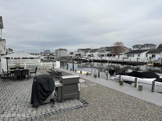 dock area with a water view and a patio