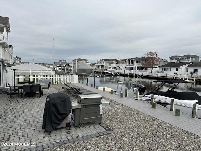 dock area with a patio and a water view