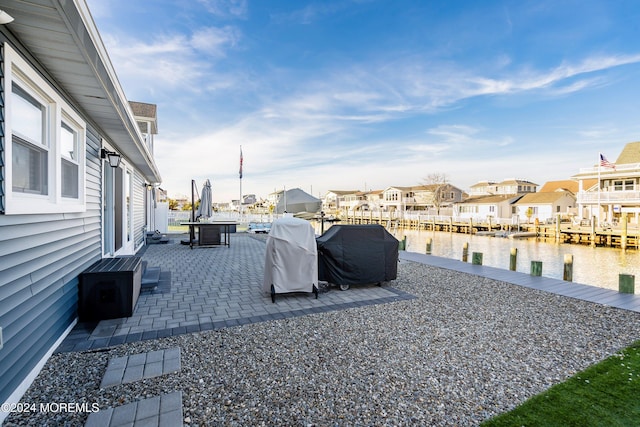 exterior space featuring a dock, a patio area, and a water view