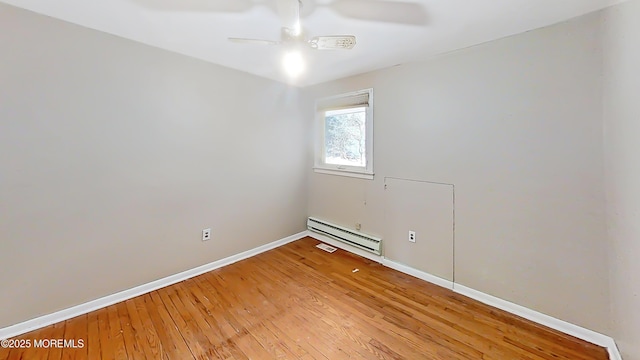 empty room featuring a baseboard heating unit, hardwood / wood-style flooring, and ceiling fan