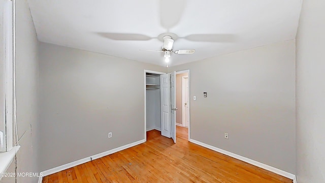 unfurnished bedroom featuring hardwood / wood-style flooring, ceiling fan, and a closet