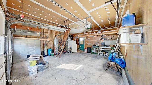 garage with water heater, white fridge, and a workshop area