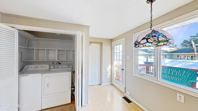 washroom featuring washer and dryer and light hardwood / wood-style flooring