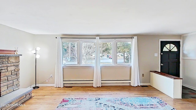 doorway with a baseboard radiator and light hardwood / wood-style floors