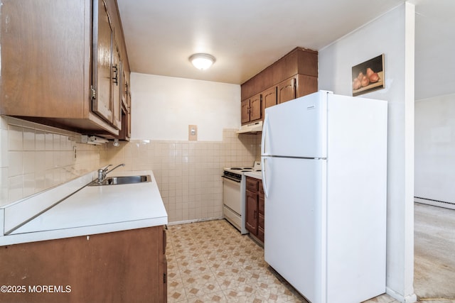 kitchen featuring tile walls, sink, and white appliances