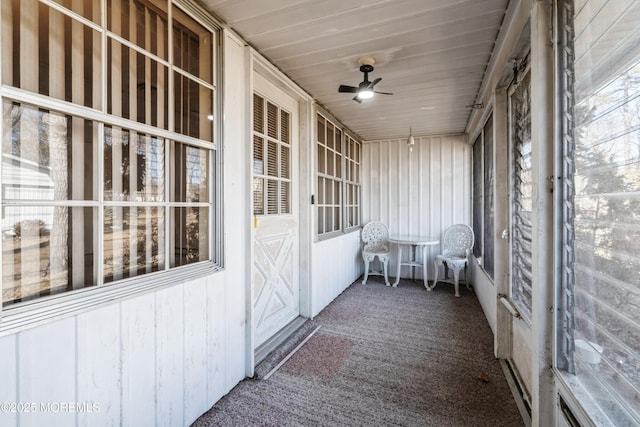 unfurnished sunroom featuring wood ceiling and ceiling fan