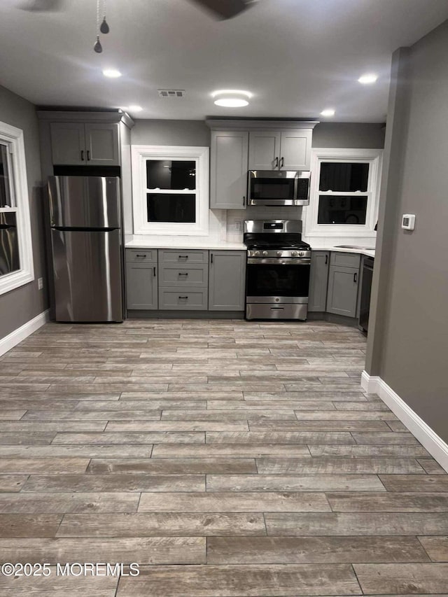 kitchen featuring stainless steel appliances and gray cabinets