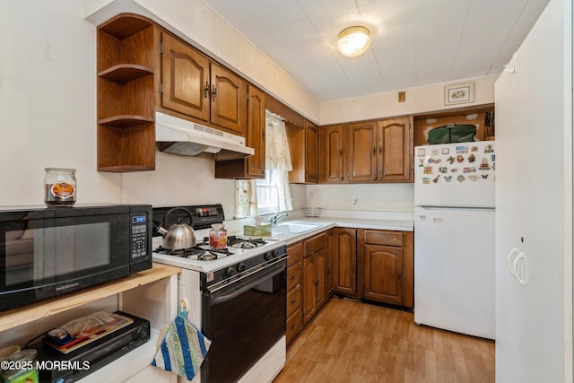 kitchen with white appliances, sink, and light wood-type flooring