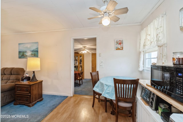 dining space featuring crown molding, ceiling fan, and wood-type flooring