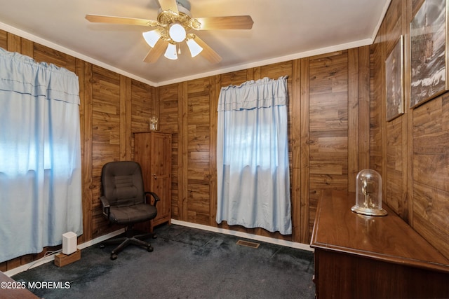 unfurnished room with dark colored carpet, ceiling fan, and wood walls