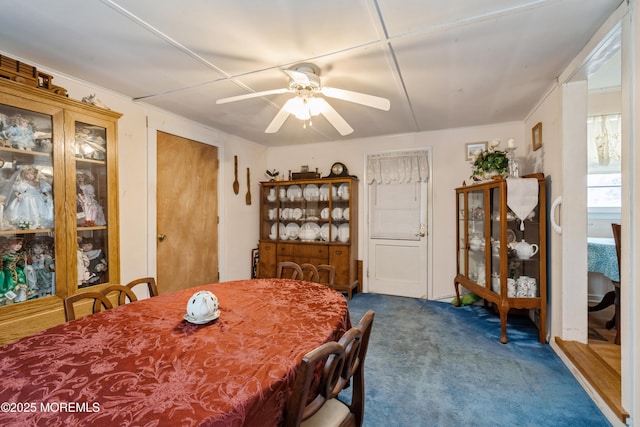 carpeted dining area with ceiling fan