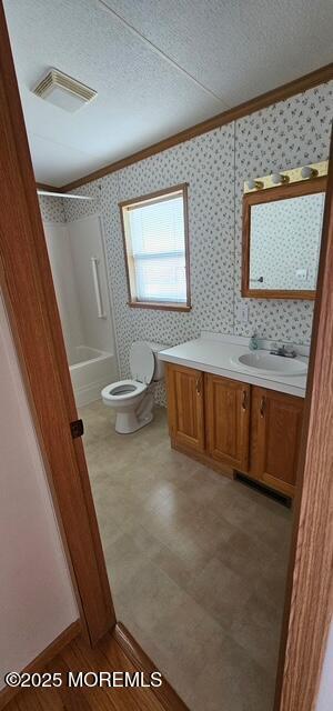 full bathroom featuring ornamental molding, vanity, a textured ceiling, and toilet