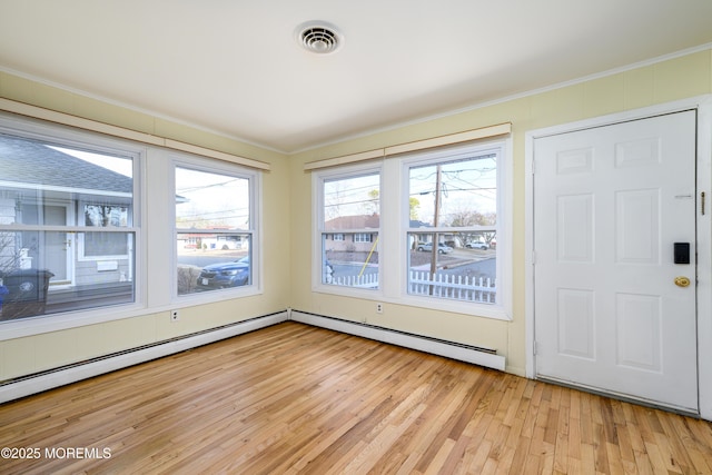 entryway with crown molding, a baseboard radiator, and light hardwood / wood-style flooring