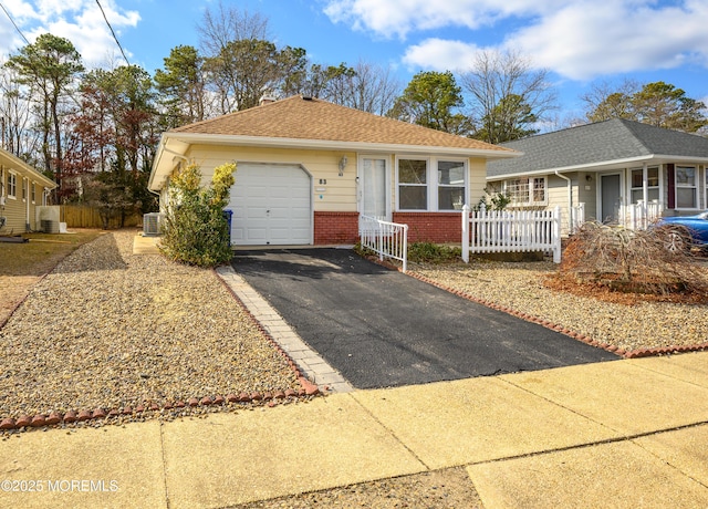 ranch-style house featuring central AC unit and a garage