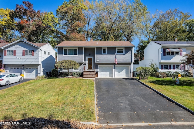 split foyer home featuring a garage and a front yard