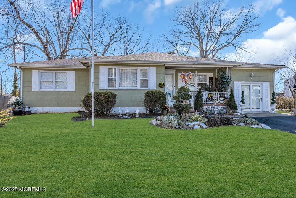 ranch-style home with a porch and a front lawn