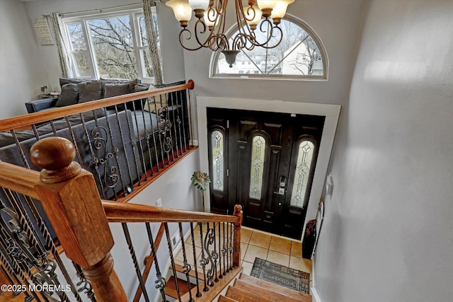 tiled entryway featuring a notable chandelier