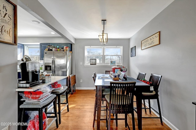 dining area featuring baseboards and light wood-style floors