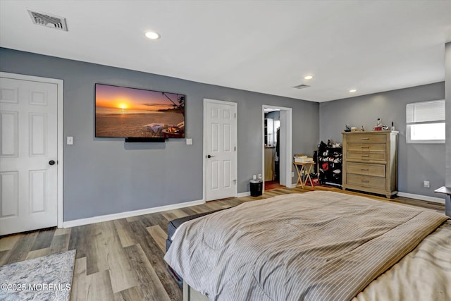 bedroom with baseboards, visible vents, wood finished floors, and recessed lighting