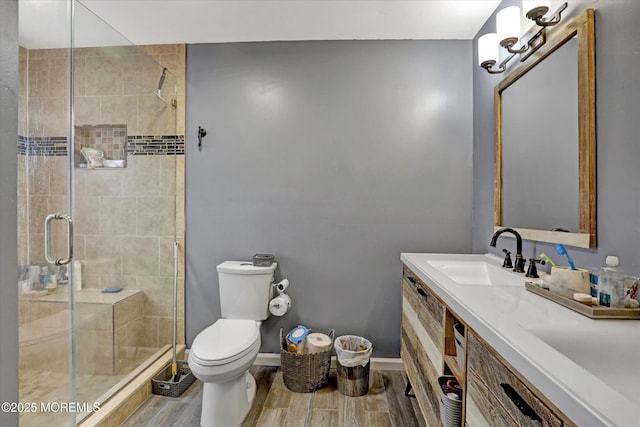 bathroom featuring a stall shower, baseboards, toilet, wood tiled floor, and vanity