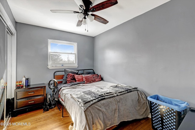 bedroom with a ceiling fan, a closet, and wood finished floors