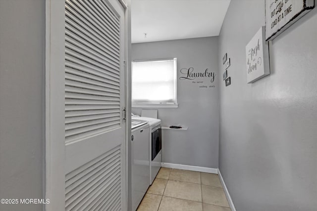 clothes washing area with laundry area, independent washer and dryer, baseboards, and light tile patterned floors