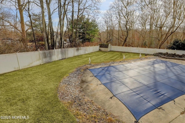 view of pool with a fenced backyard and a lawn