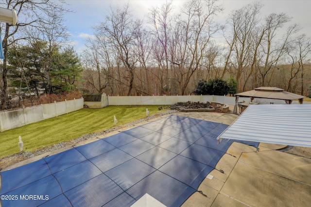 view of pool featuring a yard, a fenced backyard, a patio area, and a gazebo