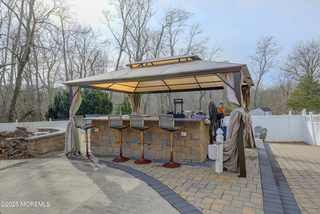 view of patio / terrace with outdoor dry bar, a gazebo, and fence