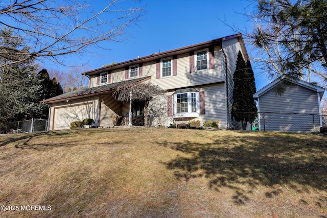 view of property featuring a garage and a front lawn