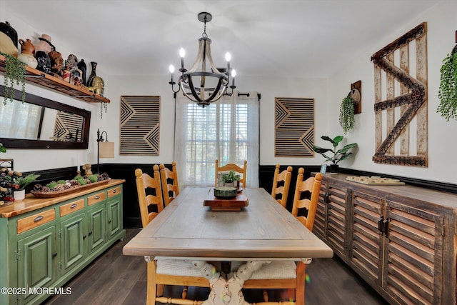 dining space featuring dark wood-type flooring and an inviting chandelier