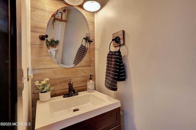 bathroom featuring vanity and wooden walls