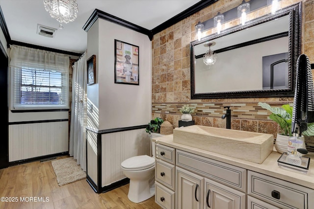 bathroom featuring crown molding, vanity, toilet, and hardwood / wood-style flooring