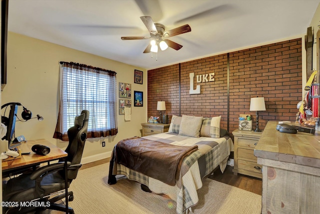 bedroom featuring ceiling fan, brick wall, and dark hardwood / wood-style flooring